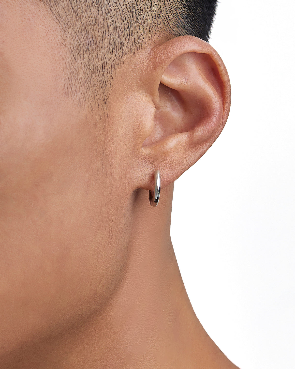 Model wearing white gold earrings by Iceman Society
